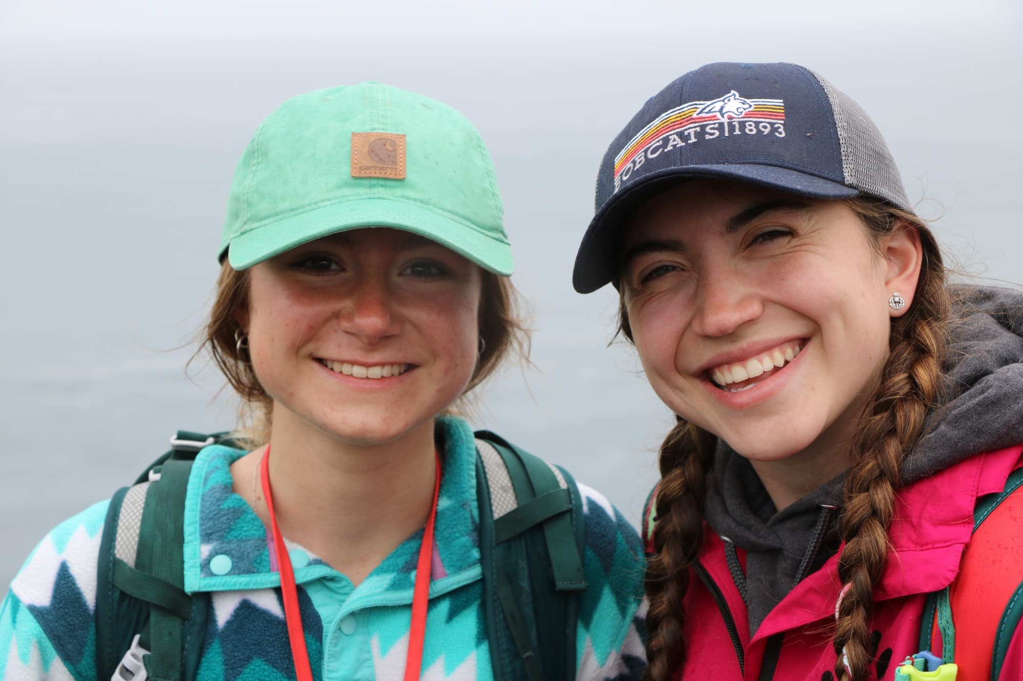 Two smiling ILE students in baseball caps